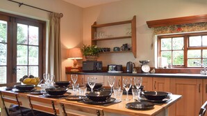 A kitchen with wooden cabinets, a central island with chairs, and a window with a view of greenery. - 3 bedroom accommodation in Hotham, near Beverley (Hotham, near Beverley)
