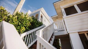 Ein weißes Gebäude mit Balkon und Treppe.