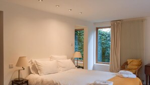 A hotel room with a large bed, two bedside lamps, a chair, and a window with curtains. - You’ll love the bright open space allowing for some real family fun. (Lothianburn, near Edinburgh)