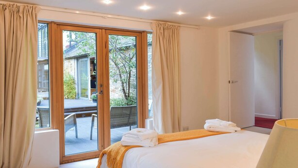 A hotel room with a bed, a window with curtains, a door, and a view of the outside. - You’ll love the bright open space allowing for some real family fun. (Lothianburn, near Edinburgh)