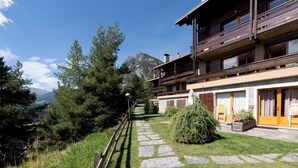 A chalet with a stone pathway, wooden deck, and mountain views. - Italianway - Bagni Nuovi 12 (Valdidentro)