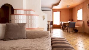 A cozy room with a bed, a small table, and a seating area with a view of the outside. - Italianway - Funivie 6A (Bormio)