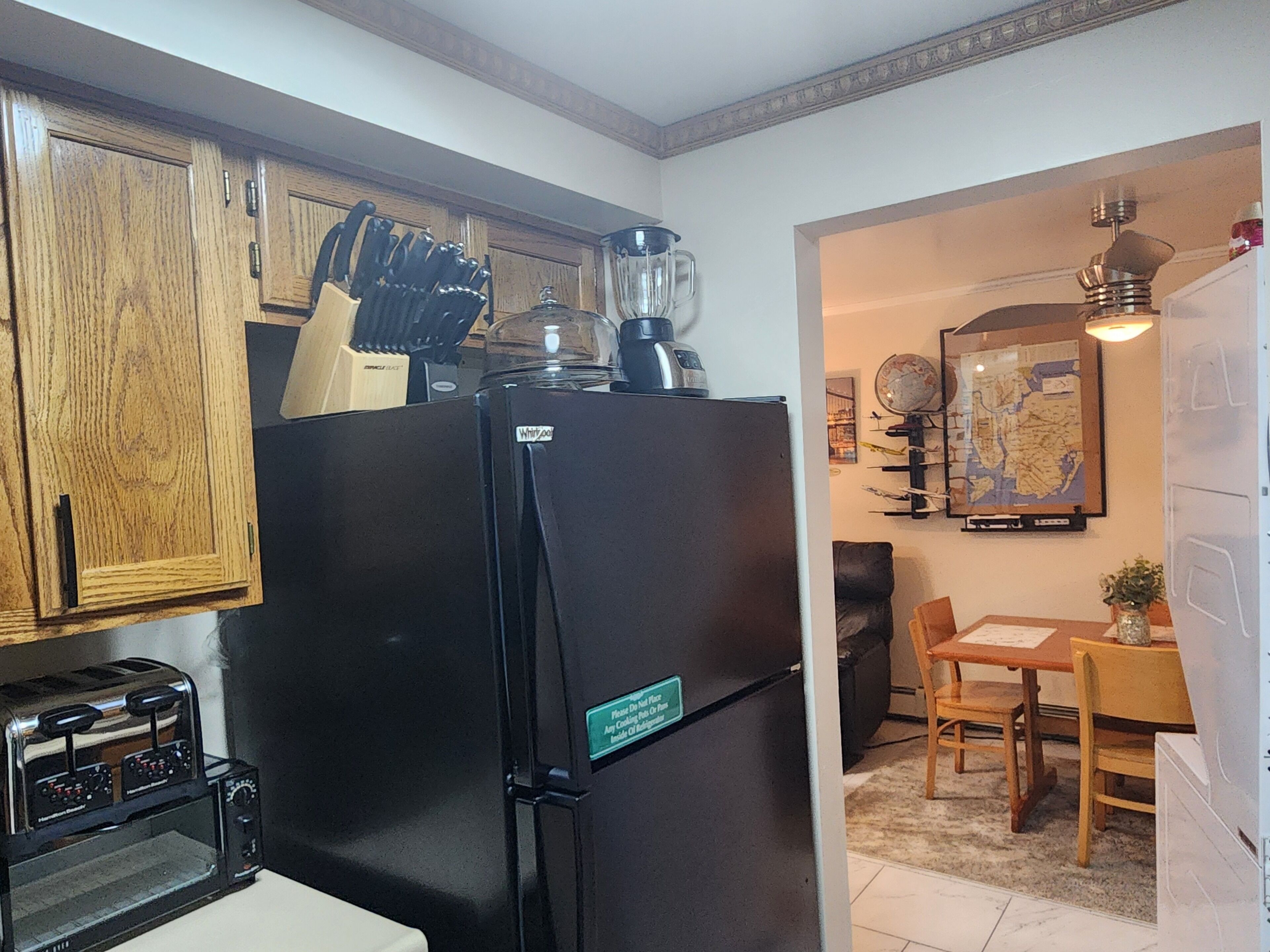 Eine Küche mit einem schwarzen Kühlschrank, einem Toaster und Holzschränken.