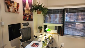 Ein moderner Arbeitsplatz mit Schreibtisch, Stuhl, Computer und Dekoration.