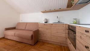 A compact kitchenette with a wooden cabinet, a built-in oven, and a small countertop. - Italianway - Besta 2 (Bormio)