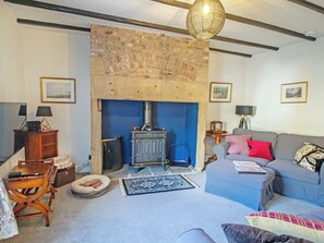 Una sala de estar con chimenea, un sofá, una mesa y una lámpara.