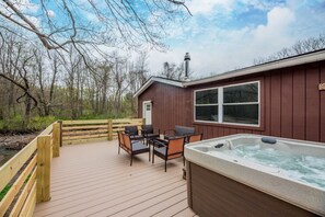 A wooden deck with outdoor seating and a hot tub.