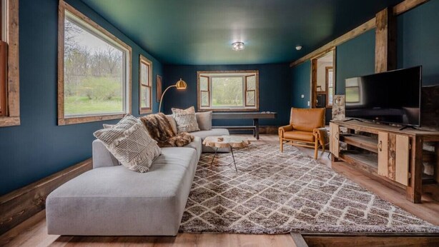 Een woonkamer met een bank, fauteuil en tv-meubel.