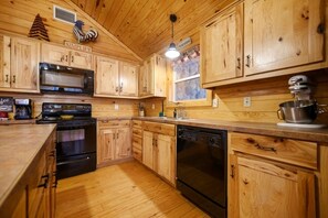 A wooden kitchen with a microwave, coffee maker, and dishwasher.