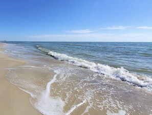 A beach with waves gently lapping onto the shore. - Vacation Rental in Beach-Front Neighborhood with Pool Access (Port St. Joe)