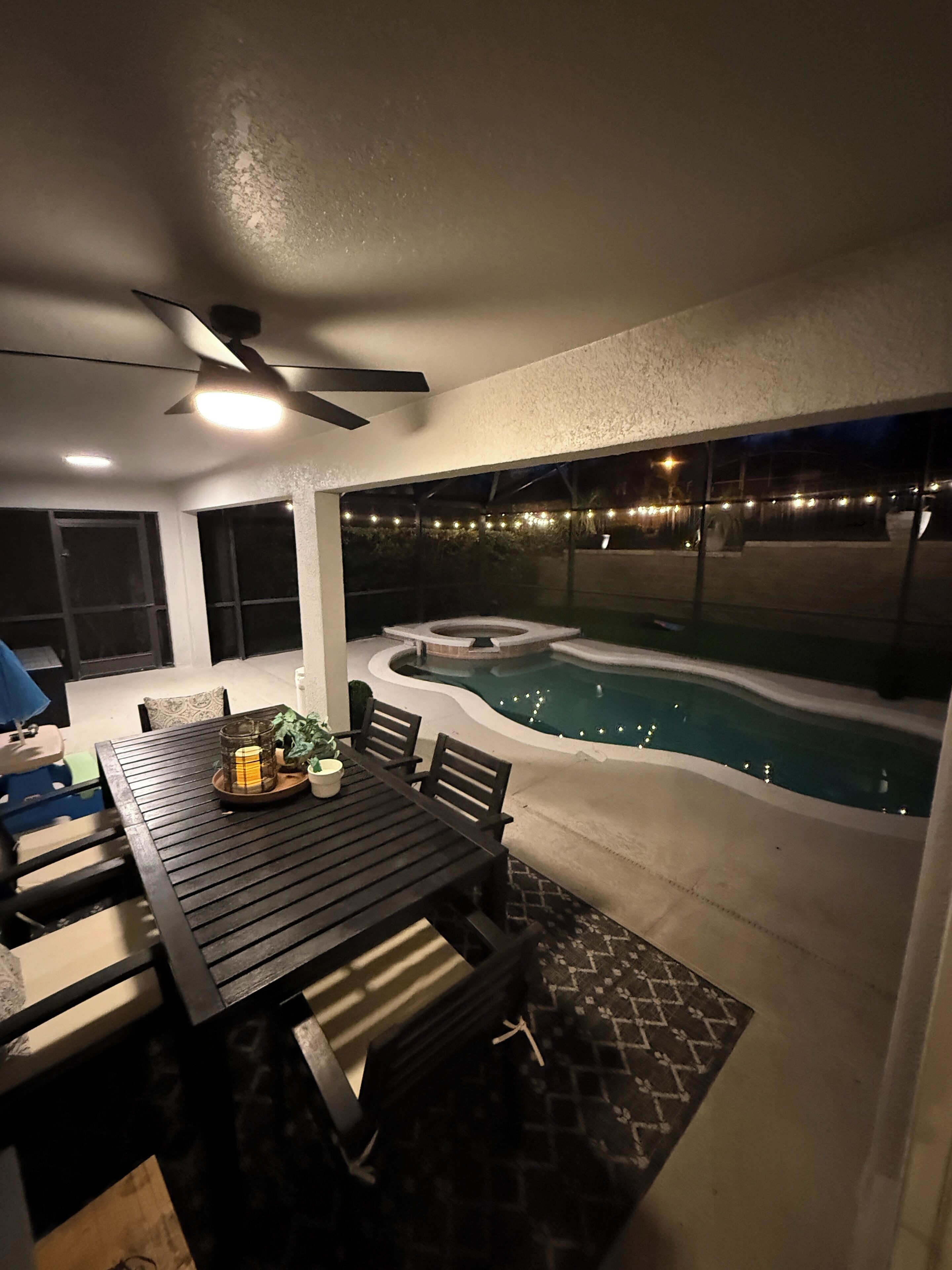Un patio exterior con mesa, sillas y un jacuzzi.