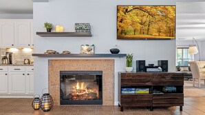 Ein modernes Wohnzimmer mit Kamin, Flachbildfernseher und Bücherregal.