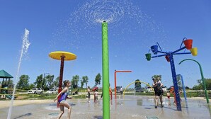 Un área de juegos acuáticos con múltiples chorros de agua y estructuras recreativas.