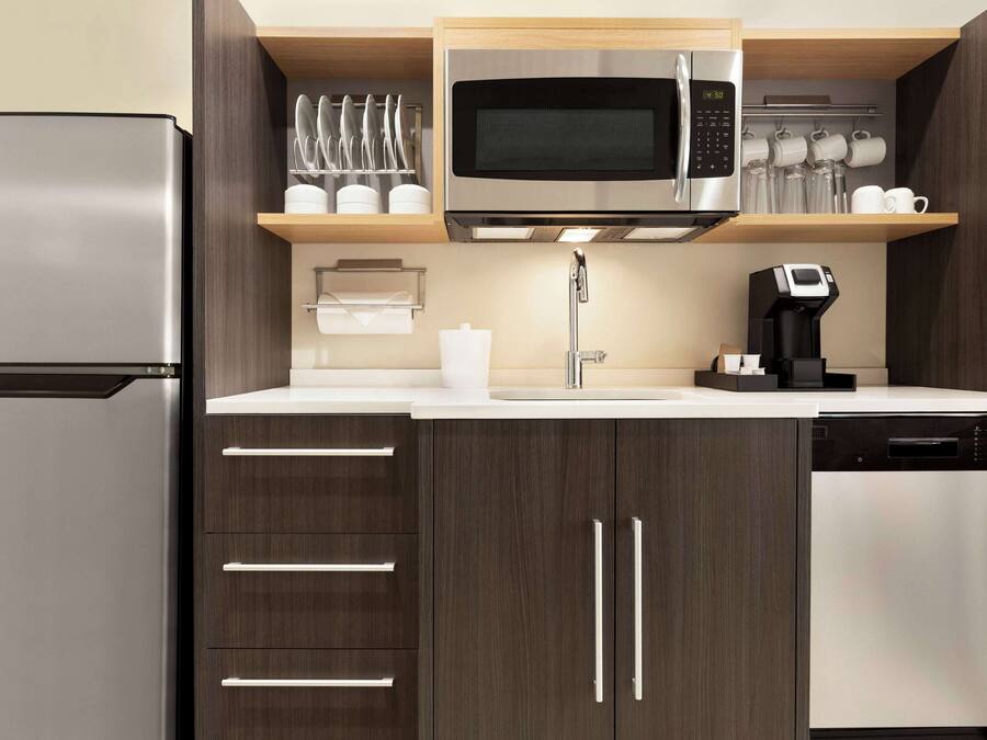 A modern kitchen with a stainless steel refrigerator, a microwave, and a coffee maker.