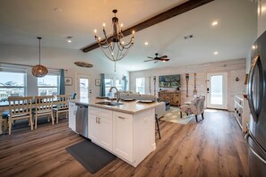 A spacious kitchen with a large island, wooden flooring, and modern appliances.