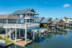 A waterfront property with a two-story building, a dock, and a small boat.