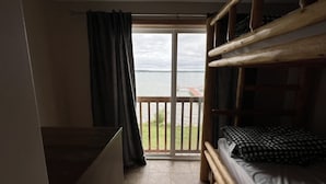 Een kamer met balkon, bed en bureau.