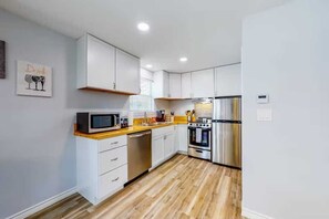 Fully equipped kitchen with microwave, coffee maker, toaster, dishwasher, and refrigerator.