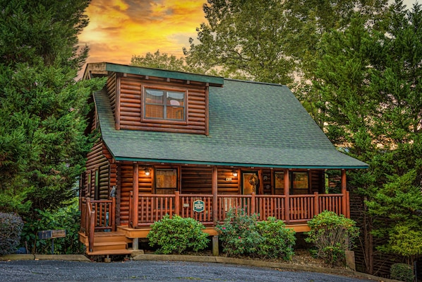 A log cabin with a porch, a small window, and a sign indicating it is a lodge.