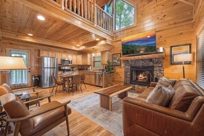 Relax in this cabin-style lodging with a high-ceilinged living area, leather sofa, and stone fireplace.