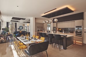 A modern kitchen with a central island, stainless steel appliances, and pendant lighting.