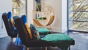 A modern living room with a black sofa, green cushions, and a gold-framed side table with decorative items. - Reservoir View -  a modern home that sleeps 8 guests  in 4 bedrooms (Cheddar)