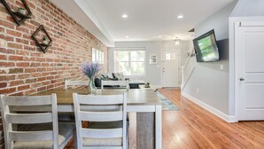 A dining area with a brick wall, wooden table, and chairs. - Private Patio + Parking + Near H Street & DC Attractions  Great for Families! (Washington)