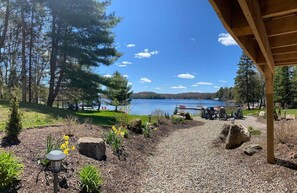 A lakeside view with a gazebo, gravel path, and outdoor seating area. - "Farm House" on Lake of Bays-Muskoka (Waterfront) (Huntsville)
