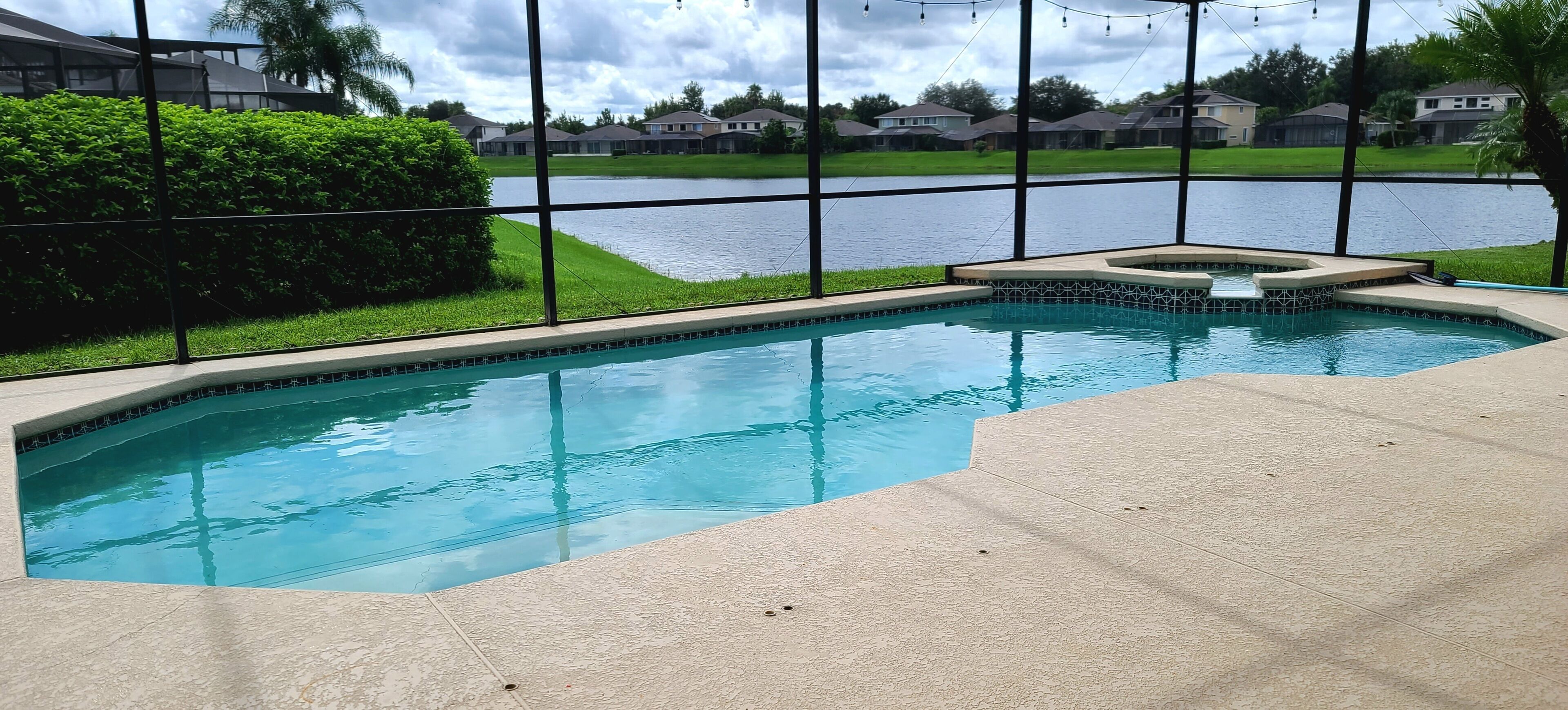 A swimming pool with a view of a lake and houses in the background.