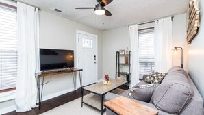 A living room with a flat-screen TV, a ceiling fan, a wooden coffee table, a gray sofa, and a bookshelf. - This house is a 2 bedroom(s), 1 bathrooms, located in Frankfort, KY. (Frankfort)