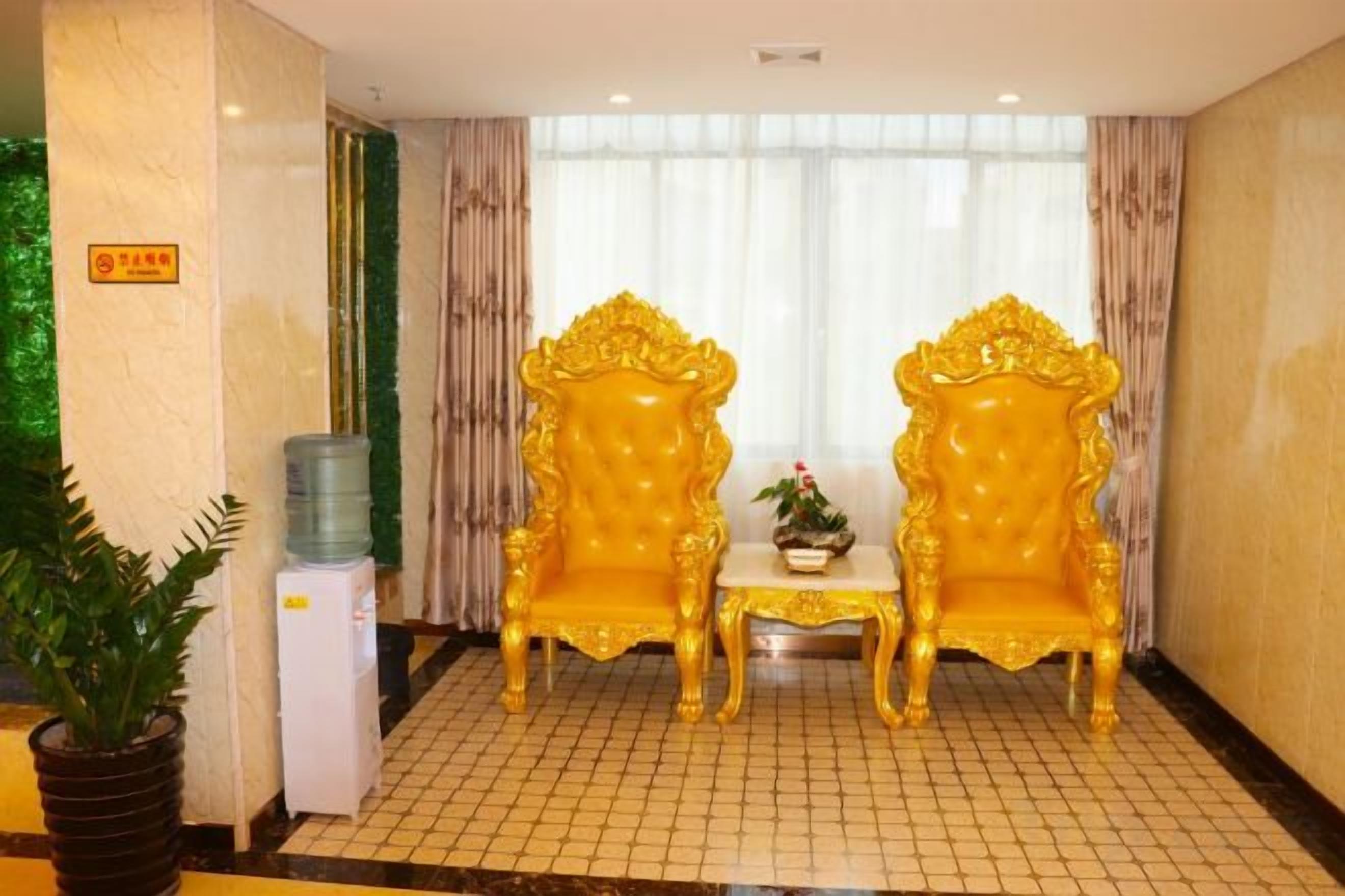 A room with two ornate golden chairs, a small table, and a water dispenser.
