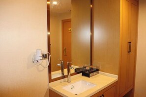 A bathroom with a sink, mirror, and hairdryer. - Fuhe Hotel (Guangzhou)