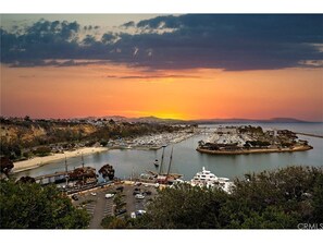 A marina with boats, a bridge, and a sunset over the water.