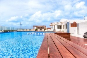 Una piscina al aire libre, tumbonas