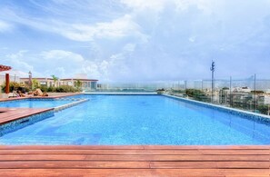 Una piscina al aire libre, tumbonas