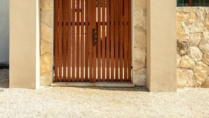 Een moderne gevel met een stenen façade en een houten poort.