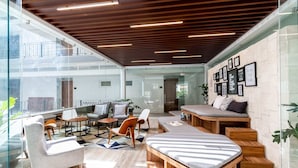 A modern interior with a glass wall, wooden ceiling, and a seating area with a sofa and chairs. - Casa Zapata Avida Lush Jungle-city-cathedral View! (Puerto Vallarta)