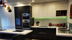 A modern kitchen with a central island, built-in ovens, and a sleek countertop.