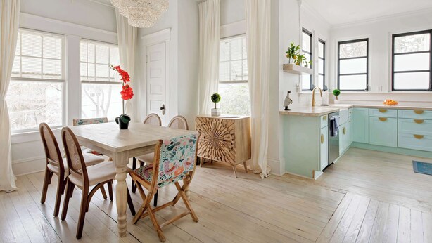A bright dining area with a wooden table, chairs, and a chandelier. - Lace and Leather (Atlanta)