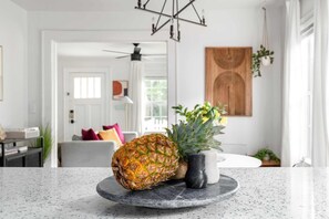 A kitchen with a granite countertop, a pineapple, and a small potted plant. - A Hard Day's Night (Atlanta)