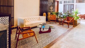 A spacious lobby with a white sofa, wooden chairs, a coffee table, and a patterned floor. - New Luxe Spacious Loft ! Private Pool & Garden!! (Tulum)
