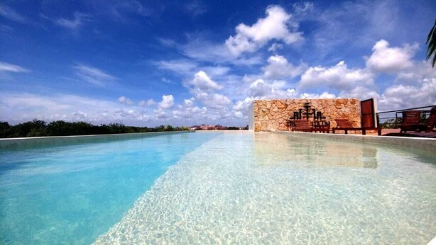 A clear pool with a stone wall and lounge chairs. - New Luxe Spacious Loft ! Private Pool & Garden!! (Tulum)