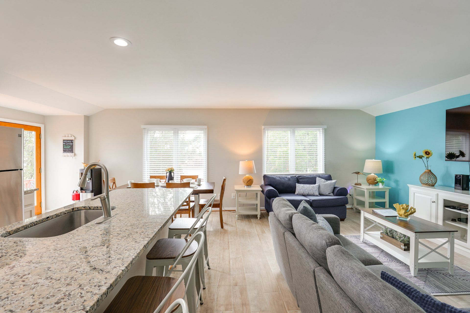 A modern kitchen with a granite countertop and a dining area with a table and chairs.