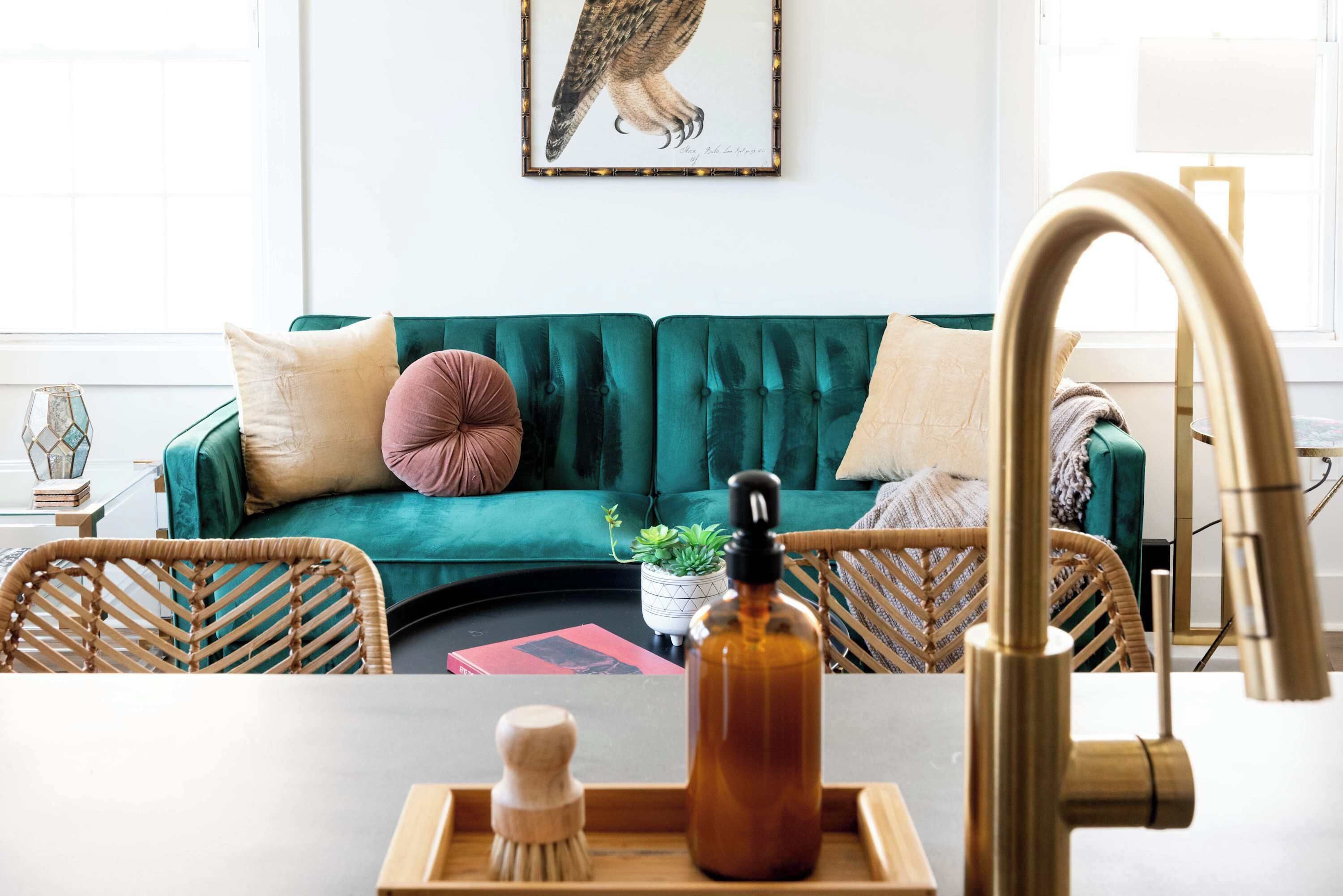 A living room with a teal sofa, a wooden coffee table, and a brass faucet.