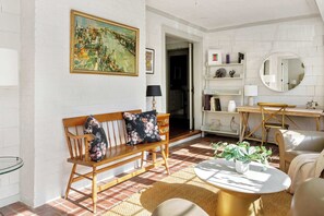 A living room with a wooden bench, a round coffee table, and a painting on the wall. - Chateau Marminty (Atlanta)