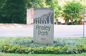 A stone monument with the inscription "Ansley Park 1904" surrounded by greenery. - Chateau Marminty (Atlanta)