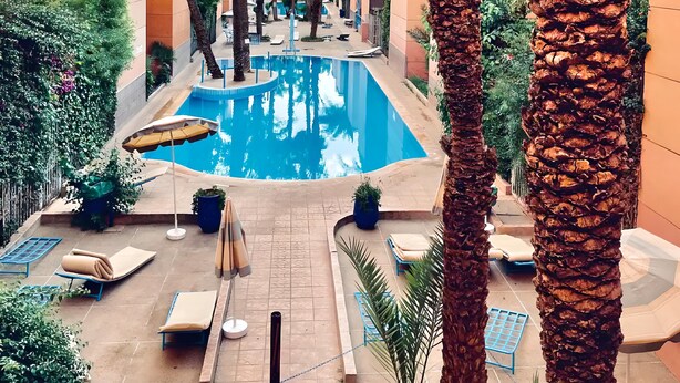 A pool area with lounge chairs and palm trees. - Beautiful Riad in Marrakech with swimming pools (Marrakech)