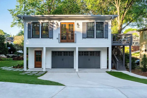 A two-story house with a front porch, a balcony, and a garage.