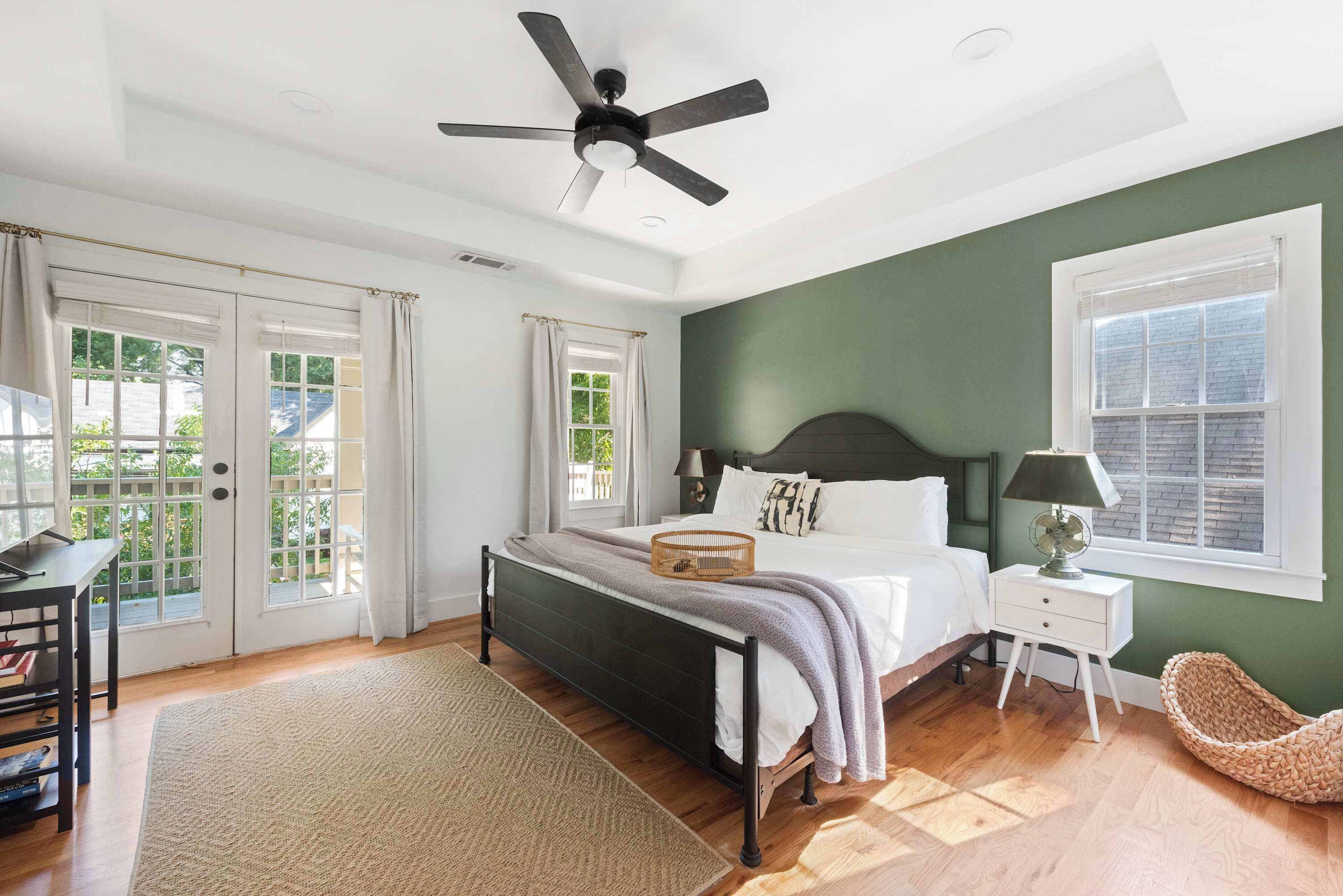 A bedroom with a bed, bedside table, and a ceiling fan.
