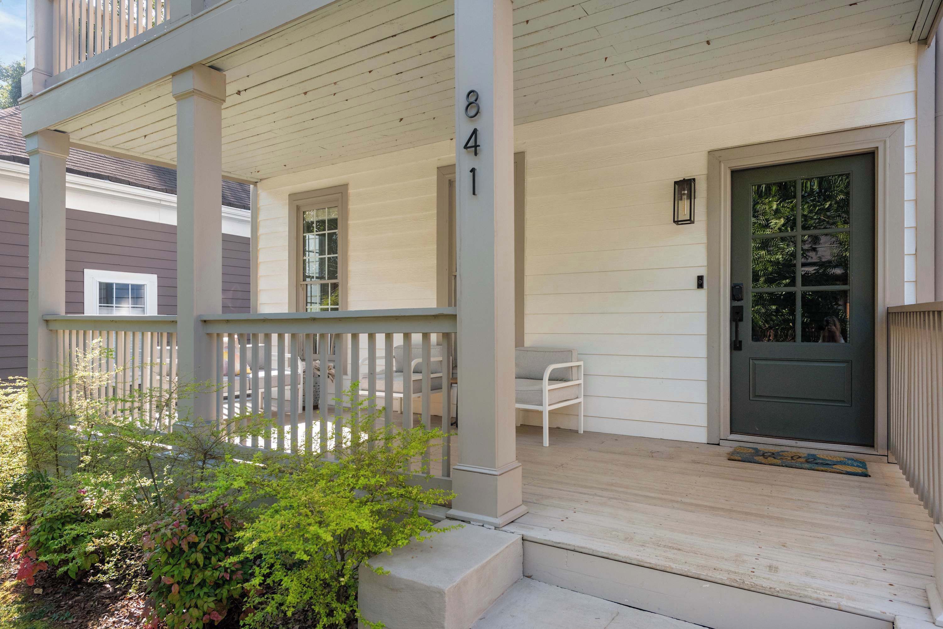 A porch with a number 841, a door, and a small garden area.